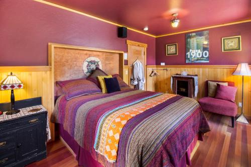 a bedroom with a large bed and a purple wall at Juniper Lane Guest House in Friday Harbor