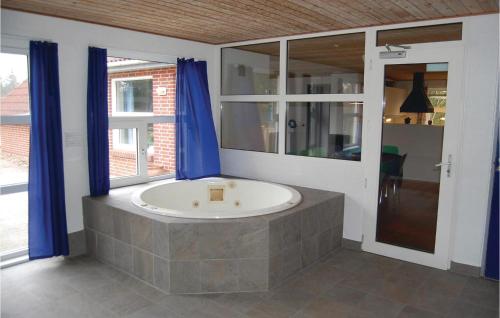 ブラーバンドにあるStunning Home In Blvand With 5 Bedrooms, Sauna And Wifiのバスルーム(青いカーテン付きの大きなバスタブ付)
