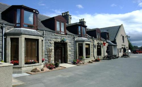 a large stone building with flowers in front of it at Ban-Car Hotel in Cairness
