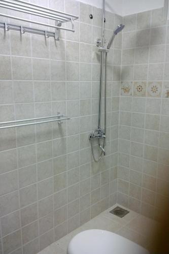 een badkamer met een douche en een toilet. bij Believe Inn in Nuwara Eliya