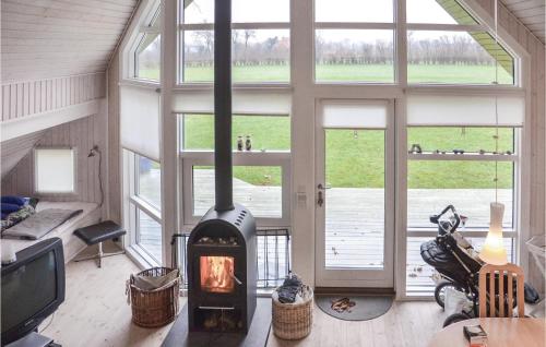 a living room with a fireplace in a room with windows at Holiday Home Asperup 55 in Asperup