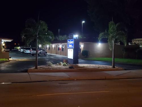 a gas pump in a parking lot at night at Travel Inn of Riviera Beach in Riviera Beach