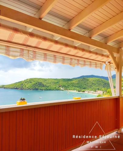 a view of the water from the balcony of a house at Résidence Séjourné in Les Anses-dʼArlets
