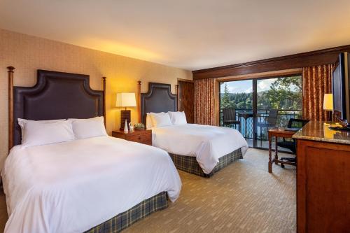 a hotel room with two beds and a balcony at Lake Arrowhead Resort & Spa in Lake Arrowhead
