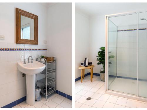 a bathroom with a glass shower and a sink at Akarana Beach House by Jervis Bay Rentals in Vincentia