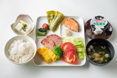 a white plate of food with rice and vegetables at Dream Village Kitakami in Kitakami