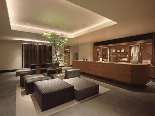 a living room with a couch and chairs and a counter at Hotel Great Morning in Fukuoka