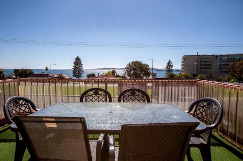 a table and chairs on a patio with a fence at Blue Seas Motel in Port Lincoln