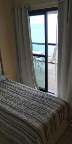 Schlafzimmer mit einem Fenster mit Meerblick in der Unterkunft PortoRealResort-Apto in Mangaratiba
