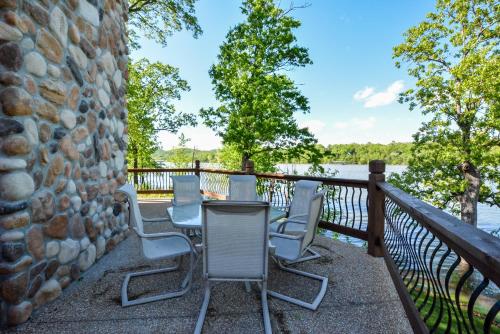 a table and chairs on a balcony overlooking a lake at Luxury Lakefront Chalet Resort 2 Pools FREE Amenities Dock MiniGolf Waterslide in Lampe