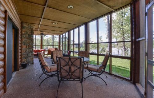 a screened in porch with a table and chairs at Luxury Lakefront Chalet Resort 2 Pools FREE Amenities Dock Kayaks Waterslide in Lampe