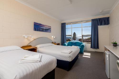a hotel room with two beds and a window at Blue Seas Motel in Port Lincoln