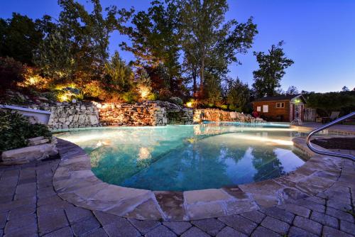 a swimming pool in a backyard at night at Chalets Resort LAKEFRONT Cottage Free Amenities Amazing views Kayaks 2 Pools in Lampe