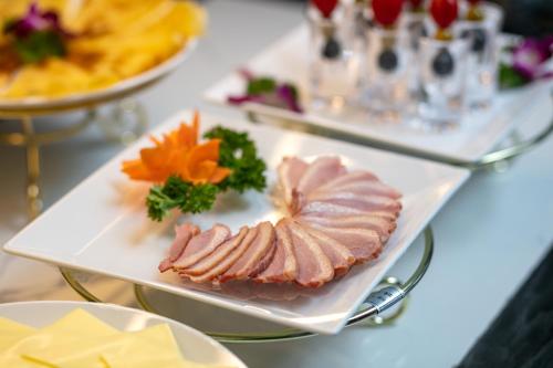 a plate of food with meat and vegetables on a table at Shining Central Hotel & Spa in Hanoi