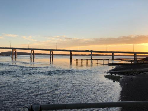 a bridge over the water with the sunset in the background at Birch House in Cowes