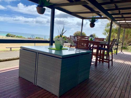 a patio with a table and chairs on a deck at Pine View Holiday Rental in Emu Bay
