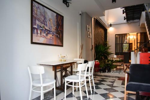 a dining room with a table and white chairs at 87 Oldtown at River Pier in Bangkok