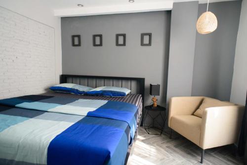 a bedroom with a blue bed and a chair at 87 Oldtown at River Pier in Bangkok