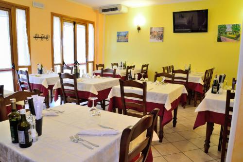 a restaurant with tables and chairs with white tablecloths at Agriturismo Bortolino in Volta Mantovana