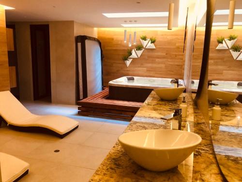 y baño con 2 lavabos y bañera. en Jacuzzi Piscina Sauna Turco Suite Lujosa, en Quito