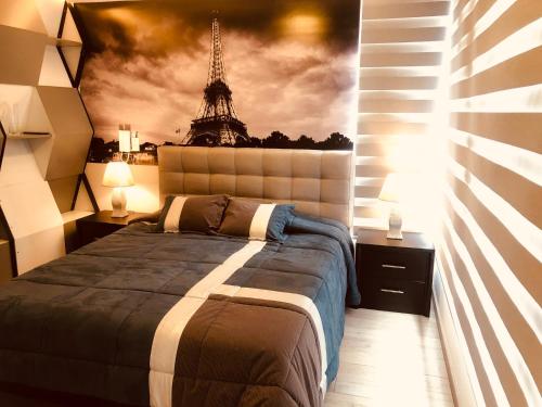 1 dormitorio con 1 cama y una pintura de la torre Eiffel en Jacuzzi Piscina Sauna Turco Suite Lujosa, en Quito