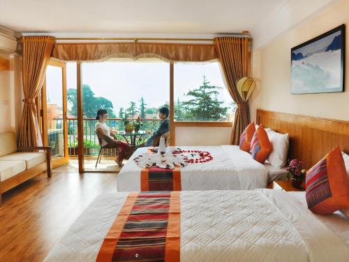 ein Hotelzimmer mit 2 Betten und einem Balkon in der Unterkunft Sapa Panorama Hotel in Sa Pa