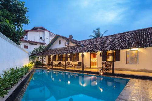 a villa with a swimming pool in front of a house at Green Casa in Galle