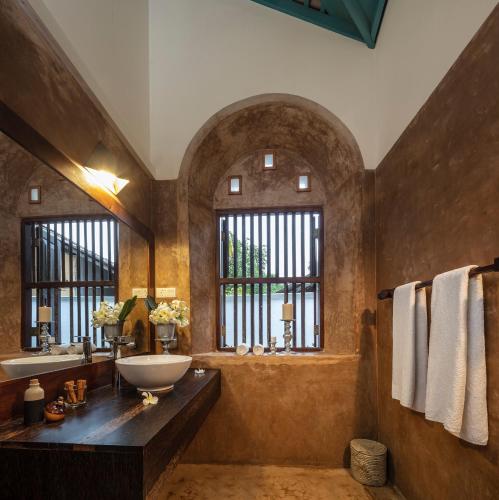 a bathroom with a sink and a tub and windows at Green Casa in Galle