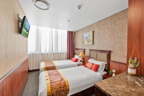 a hotel room with two beds and a television at YEHS Hotel Sydney CBD in Sydney