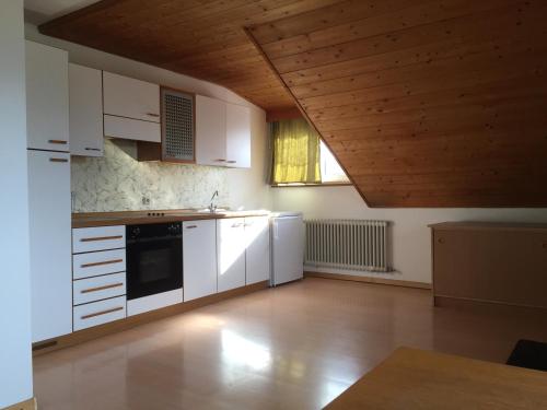 Il comprend une cuisine avec des appareils blancs et un plafond en bois. dans l'établissement Schönhuberhof - Panoramalage, à Brunico