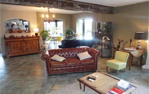 a living room with a leather couch and a table at Stunning Home In Caux in Caux