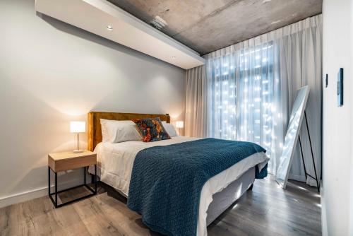 ein Schlafzimmer mit einem Bett und einem großen Fenster in der Unterkunft 402 The Signature, De Waterkant in Kapstadt