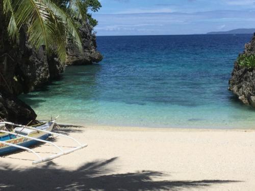 a beach with two lounge chairs and the ocean at Turtle Cove Exclusive Island Resort in Calatrava