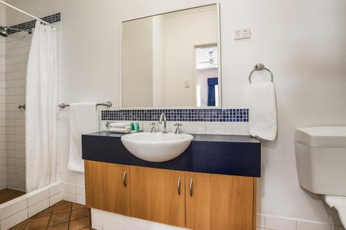 a bathroom with a sink and a toilet at Karratha Central Apartments in Karratha