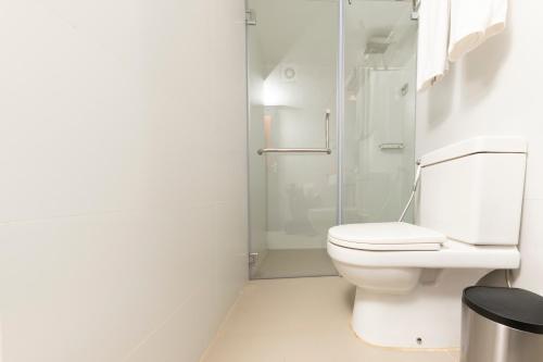 
a white toilet sitting in a bathroom next to a shower at Citrus Hikkaduwa in Hikkaduwa
