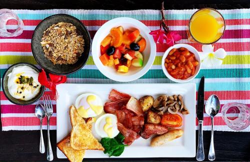 a table with a plate of breakfast food and drinks at Ramada Suites by Wyndham Zen Quarter Darwin in Darwin
