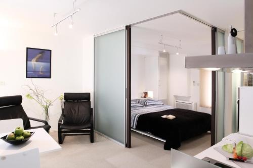 a room with a bed, chair and a mirror at Miró Studio Apartments Dubrovnik in Dubrovnik