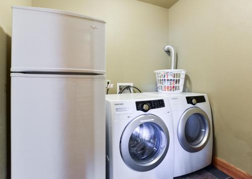 a refrigerator and a washing machine in a room at Luxury Lakefront Chalet Resort 2 Pools FREE Amenities Dock MiniGolf Waterslide in Lampe