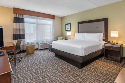 a hotel room with a large bed and a large mirror at Wyndham Garden Buffalo Downtown in Buffalo