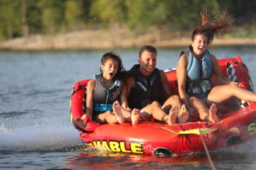 a group of people sitting on a raft on the water at Chalets Resort LAKEFRONT Cottage Free Amenities Amazing views Kayaks 2 Pools in Lampe
