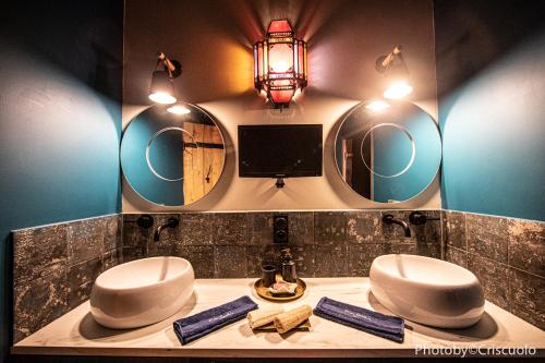 a bathroom with two sinks and two mirrors at Le Hammam du Panier in Marseille