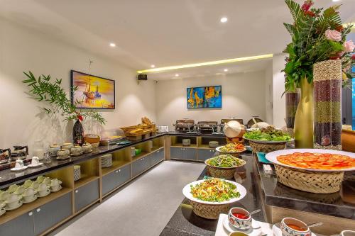 a kitchen with a buffet with lots of food at Hoi An Aurora Riverside Hotel and Spa in Hoi An