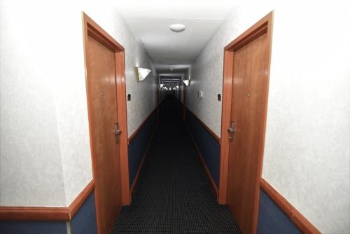 a hallway with two doors and a long corridor at FairBridge Hotel Atlantic City in Galloway