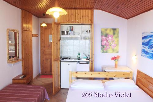 a small room with a bed and a kitchen at Fasoli Studios in Paralia Panteleimonos