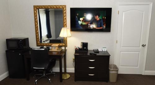 a room with a desk and a mirror and a desk with a chair at FairBridge Hotel Atlantic City in Galloway