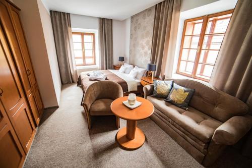 a living room with a couch and a bed at Penzion Pod Zamkem in Jindrichuv Hradec