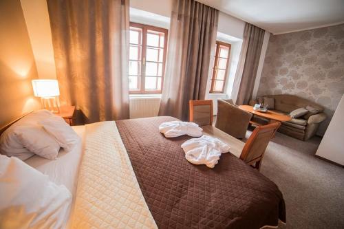 インドルジフーフ・フラデツにあるPenzion Pod Zamkemのベッドとリビングルームが備わるホテルルームです。