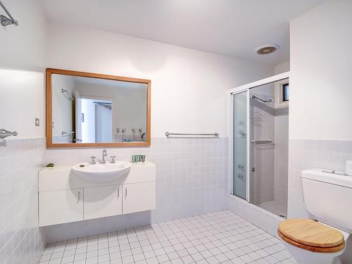 a white bathroom with a sink and a shower at The Shack in Seal Rocks