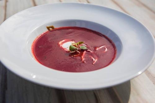 a bowl of red soup on a white plate at Penzion Pod Zamkem in Jindrichuv Hradec