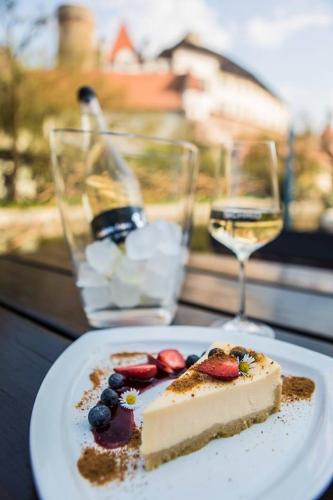 a piece of cake on a plate with a glass of wine at Penzion Pod Zamkem in Jindrichuv Hradec